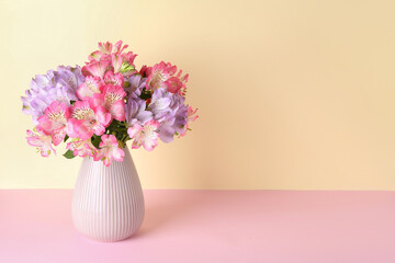 Beautiful alstroemeria flowers in vase on color background, space for text