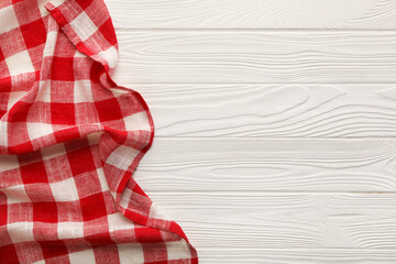Obraz premium Red checkered picnic tablecloth on white wooden table, top view. Space for text