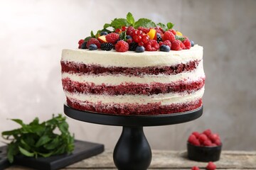 Tasty sponge cake with different fruits and mint on table