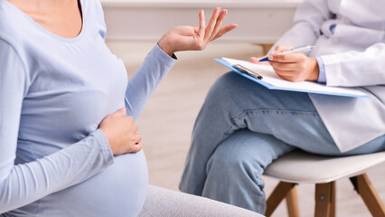 Doctor's Appointment. Unrecognizable Pregnant Woman Talking With Therapist During Medical Check Up In Office. Cropped, Selective Focus