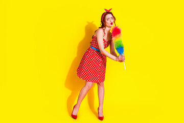 Photo of funky lovely charming lady wear red stylish dress hold duster clean house isolated on vivid yellow background