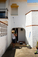 Caucasian man painting a house, perfect for home renovation and DIY projects