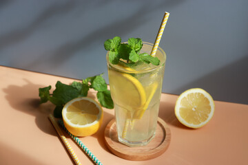 Glass of lemonade with fresh lemon sliced and mint leaf for summer drink.