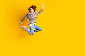 Obraz premium Full size photo of crazy guy dressed ornament sweater jeans jump near empty space give highfive isolated on yellow color background