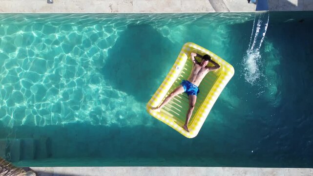 Friends at swimming pool aerial drone view of people that swim at pool floating over inflatable bed in chalet at residential area.