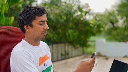 Indian young man doing payment with smartphone using QR code