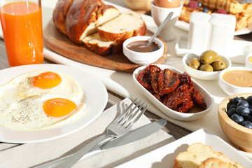 Different meals served for breakfast on wooden table