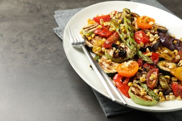 Delicious salad with grilled vegetables served on gray textured table, closeup. Space for text