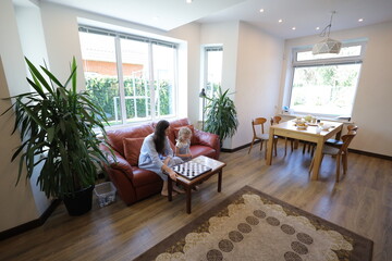 Mother and a child playing chess at home