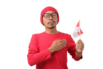 Indonesian man wearing red shirt and a beanie makes a promises gesture while holding the Indonesian...
