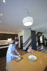 Mother and a small daughter cooking food at home in the kitchen