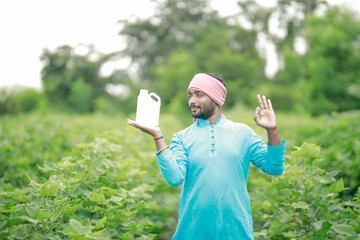 Indian village farmer holding fertilizer bottle