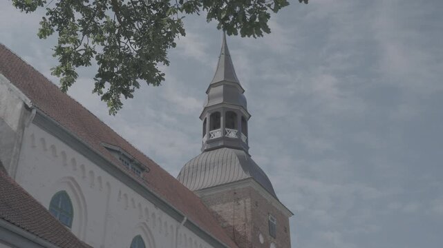 Valmiera, Larvia: ST. SIMONS CHURCH architecture close up shot slowmotion summer sunny day blue sky tree leaves 4k 10bit slog 3