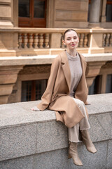 Young beautiful woman wearing coat walking in the city centre of Prague, Europe