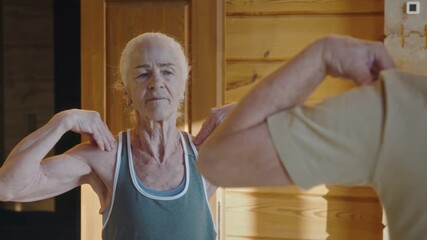 Medium close-up of senior Caucasian lady in sports top performing morning exercises with husband at home, doing waist rotation, while talking and giving instructions to avoid injury