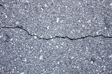 Cracked asphalt pavement top view. Cracked asphalt,road,highway,road shoulder,roadway damage. Emergency condition of the asphalt, damage.