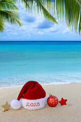 New Year 2025 background with red Santa hat on Caribbean beach.