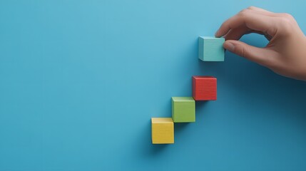  Strategic business growth concept with hand placing green and blue blocks to build an upward graph representing success in marketing and sales. Business planning, and positive trends