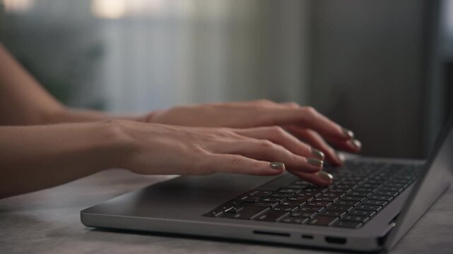 Hands Typing on Laptop Keyboard in Calm Indoor Setting