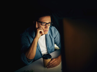 Man, computer and tired at night with coffee for programming, coding or cybersecurity research. Programmer, pc and bored in office with tea for information technology, glitch and software development