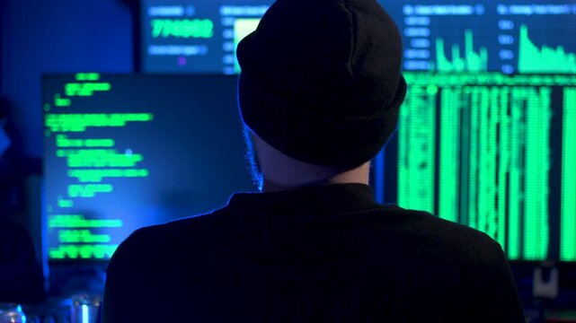 Computer hacker tying code onto a screen