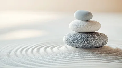 A balanced stack of smooth stones rests on sand with gentle ripples, symbolizing serenity, balance, and tranquility in a minimalist zen setting.