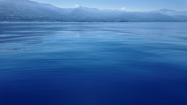 Mare blu e sullo sfondo le montagne dello stretto di Messina - Sicilia e Calabria