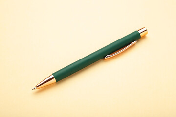 New stylish green pen on beige background. Top view