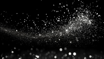 A cloud of tiny particles and dust explodes against a dark background, creating an abstract, shimmering effect in the darkness.