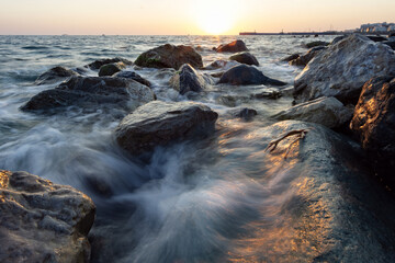 red sunset in the surf on the rocks and splashes