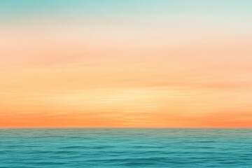 Obraz premium A gradient moving from a warm orange to a cool teal with a subtle grain effect, resembling a sunset over the ocean.