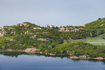 Aerial view of the island monastery on Lake Skadar, Montenegro, surrounded by pristine blue waters.