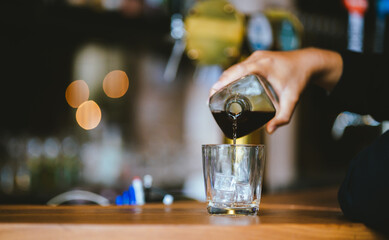 Whiskey drinks at the bar celebrating a special event in a luxury bar. Close-up shows a cheerful atmosphere as glasses clink together, reflecting a lively and joyful gathering.