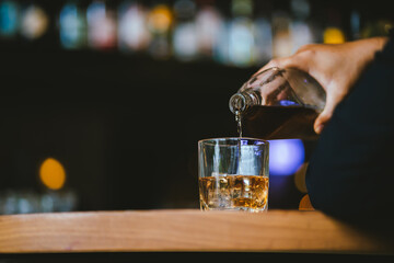Whiskey drinks at the bar celebrating a special event in a luxury bar. Close-up shows a cheerful atmosphere as glasses clink together, reflecting a lively and joyful gathering.