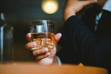 Whiskey drinks at the bar celebrating a special event in a luxury bar. Close-up shows a cheerful atmosphere as glasses clink together, reflecting a lively and joyful gathering.
