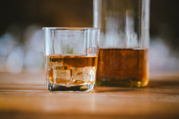 Whiskey drinks at the bar celebrating a special event in a luxury bar. Close-up shows a cheerful atmosphere as glasses clink together, reflecting a lively and joyful gathering.
