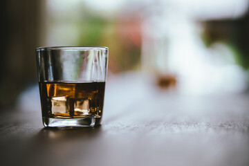 Whiskey drinks at the bar celebrating a special event in a luxury bar. Close-up shows a cheerful atmosphere as glasses clink together, reflecting a lively and joyful gathering.