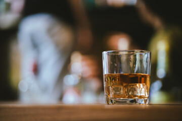Whiskey drinks at the bar celebrating a special event in a luxury bar. Close-up shows a cheerful atmosphere as glasses clink together, reflecting a lively and joyful gathering.