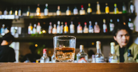 Whiskey drinks at the bar celebrating a special event in a luxury bar. Close-up shows a cheerful atmosphere as glasses clink together, reflecting a lively and joyful gathering.