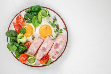 Plate of breakfast with fried eggs, ham and salad. Keto breakfast. Brunch