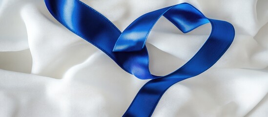 A deep blue ribbon curl on white fabric with copy space Colorectal cancer awareness colon cancer in older adults and World Diabetes Day as well as child abuse prevention Healthcare and insurance them