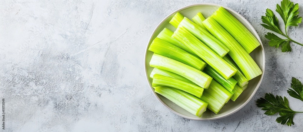 Leinwandbilder Braised celery on a plate against a light stone background with ample free text space Top view flat lay