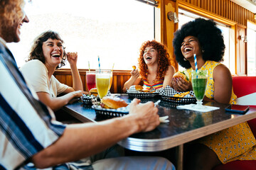 Multiethnic group of friends having meal at 80s vintage diner restaurant - Multiracial young people...