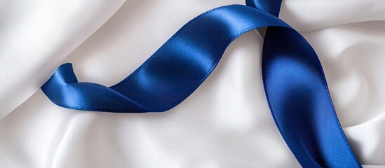 A deep blue ribbon curl on white fabric with copy space Colorectal cancer awareness colon cancer in older adults and World Diabetes Day as well as child abuse prevention Healthcare and insurance them