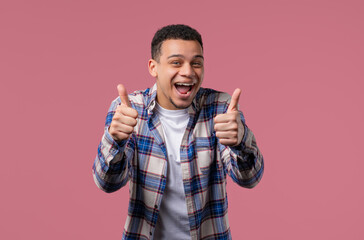 Positive stylish biracial man with LIKE sign, thumbs up gesture. Happy hipster.
