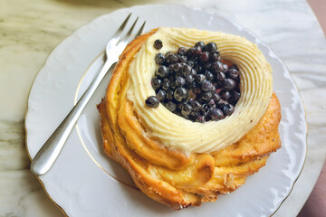 Dessert with cream and berries on a white plate.
