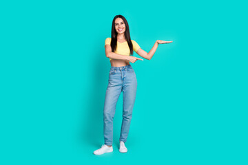 Full size photo of nice young woman point finger measure empty space wear top isolated on teal color background