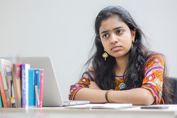 Young woman feeling bored and unmotivated at desk
