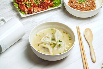 Handmade Soup Dumplings with pork chop, minced pork rice, served in dish isolated on marble background side view of taiwan food