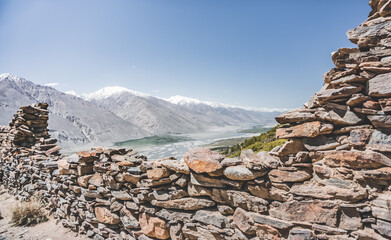 Remains of the ancient fortress of Yamchun in the Tien Shan mountains in Tajikistan in the Pamirs, ruins of a fortress fort made of stone on the background of mountains